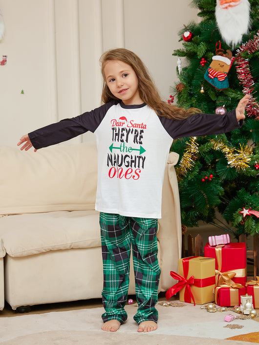 Man wearing a white and black raglan long-sleeve pajama top with a 'Dear Santa They're the Naughty Ones' graphic and green plaid pajama pants. - Image 14