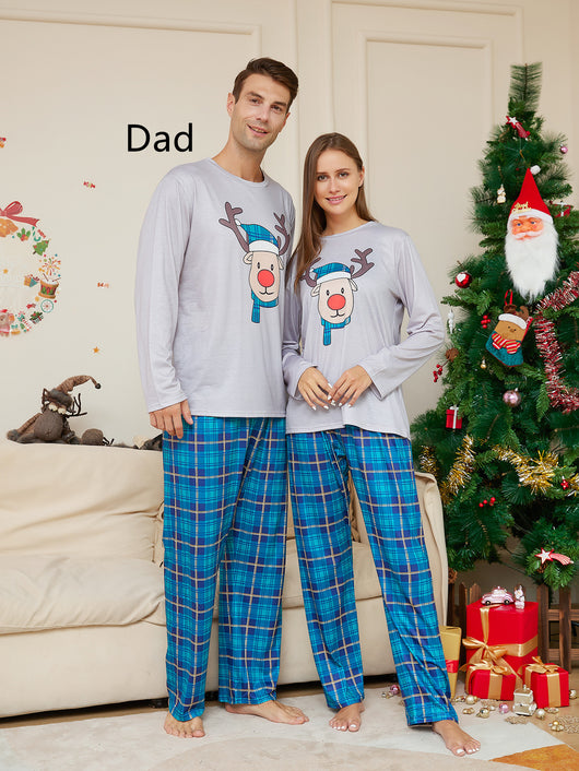 Young girl wearing a grey long-sleeve pajama top with a cartoon reindeer and blue plaid pajama pants. - Image 13