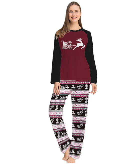 Child wearing a Christmas pajama set with a maroon and black reindeer top and black, pink, and white striped pants. - Image 10
