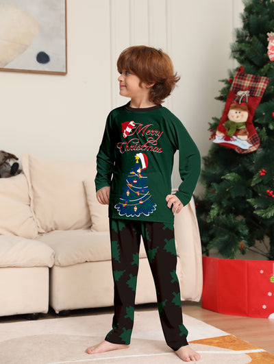 Young girl wearing a dark green long-sleeved Christmas pajama set with a decorated tree and "Merry Christmas" text. - Image 11