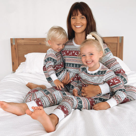 Family of four wearing matching Christmas pajamas with red, green, and white Fair Isle reindeer and snowflake pattern. - Image 11
