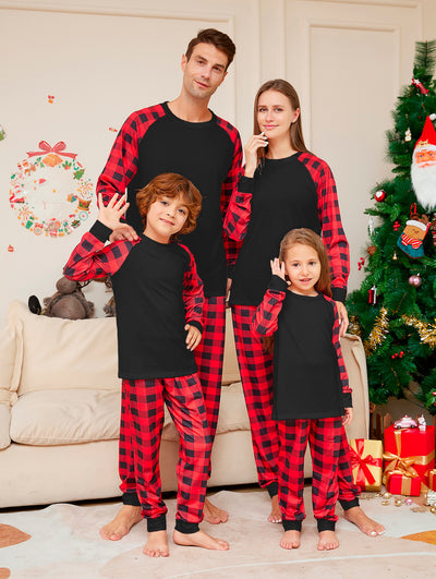 Family of four wearing matching black and red buffalo plaid pajamas in a festive Christmas living room. - Image 8