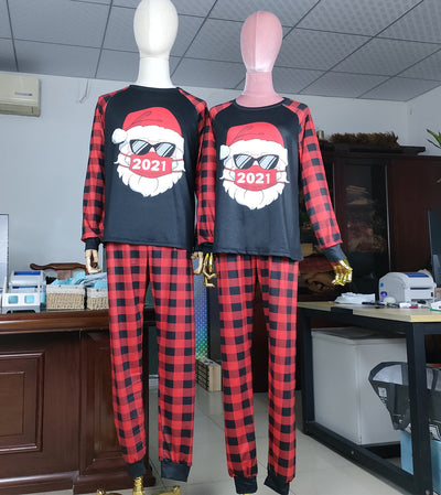 Family matching Christmas pajamas with a Santa Claus graphic wearing sunglasses and a '2021' mask, paired with red and black buffalo plaid pants. - Image 8