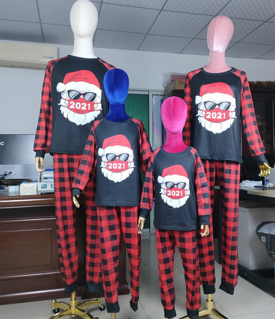 Family matching Christmas pajamas with a Santa Claus graphic wearing sunglasses and a '2021' mask, paired with red and black buffalo plaid pants. - Image 11