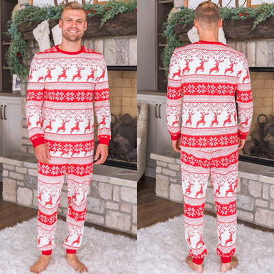 Family of eight wearing matching red and white Christmas pajamas with reindeer and snowflake patterns in a living room. - Image 17