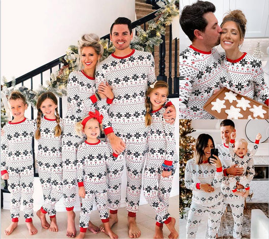Family of six wearing matching black, white, and red fair isle print Christmas pajamas with red cuffs and collars. - Image 10