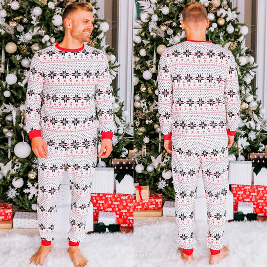Family of six wearing matching black, white, and red fair isle print Christmas pajamas with red cuffs and collars.
