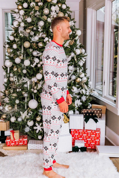 Family of six wearing matching black, white, and red fair isle print Christmas pajamas with red cuffs and collars. - Image 13