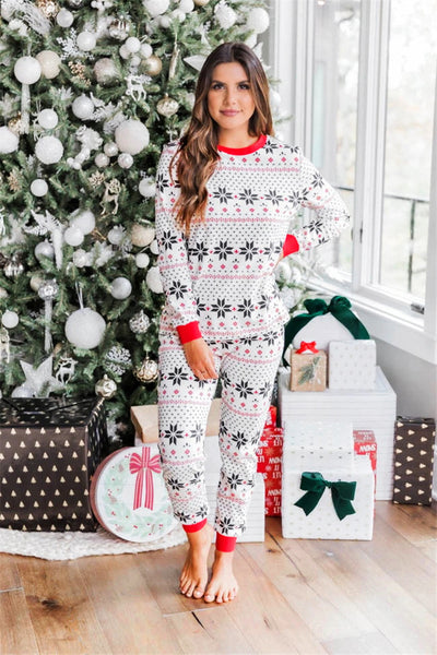 Family of six wearing matching black, white, and red fair isle print Christmas pajamas with red cuffs and collars. - Image 19