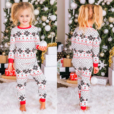 Family of six wearing matching black, white, and red fair isle print Christmas pajamas with red cuffs and collars. - Image 24