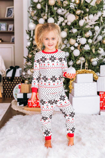 Family of six wearing matching black, white, and red fair isle print Christmas pajamas with red cuffs and collars. - Image 25