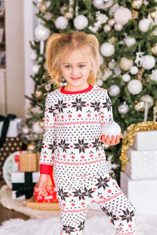 Family of six wearing matching black, white, and red fair isle print Christmas pajamas with red cuffs and collars. - Image 26