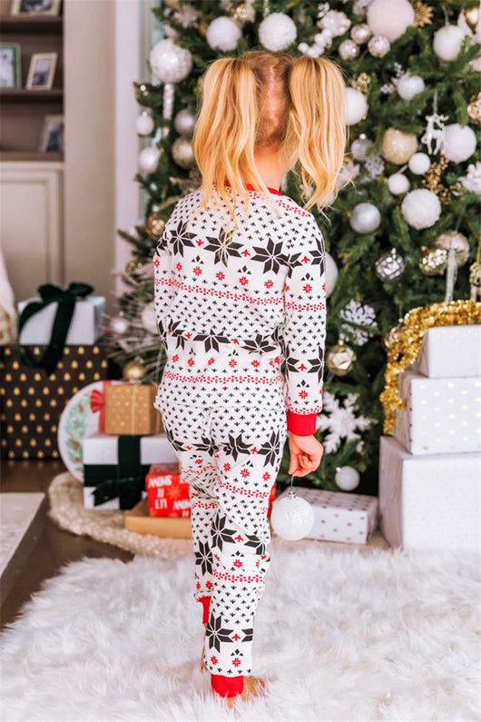 Family of six wearing matching black, white, and red fair isle print Christmas pajamas with red cuffs and collars. - Image 28