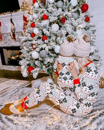 Family of six wearing matching black, white, and red fair isle print Christmas pajamas with red cuffs and collars. - Image 31
