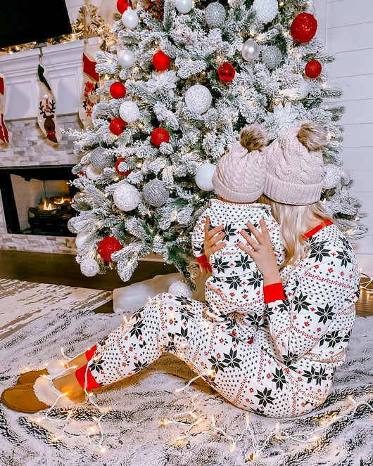 Family of six wearing matching black, white, and red fair isle print Christmas pajamas with red cuffs and collars. - Image 31