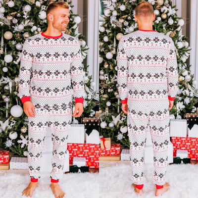 Family of six wearing matching black, white, and red fair isle print Christmas pajamas with red cuffs and collars. - Image 38
