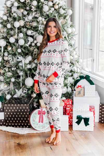 Family of six wearing matching black, white, and red fair isle print Christmas pajamas with red cuffs and collars. - Image 47