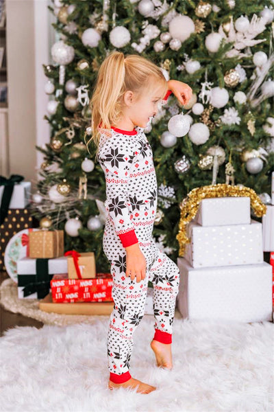Family of six wearing matching black, white, and red fair isle print Christmas pajamas with red cuffs and collars. - Image 54