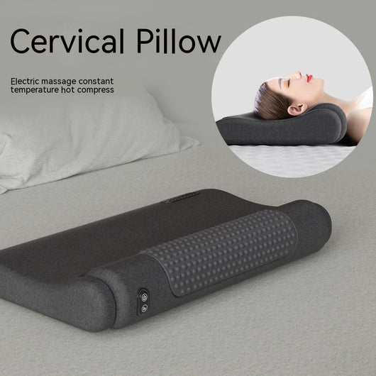 Dark gray cervical spine pillow with light gray textured massage area and power button on a light gray surface.