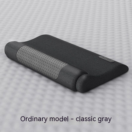 Dark gray cervical spine pillow with light gray textured massage area and power button on a light gray surface. - Image 19