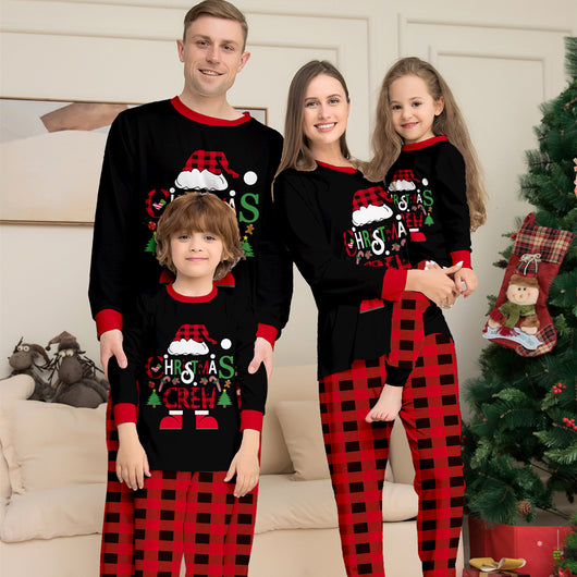 Man wearing black and red plaid Christmas pajamas with a Santa graphic top and matching pants. - Image 15