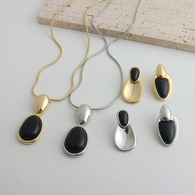 Pair of gold-toned irregular earrings with black onyx-like inserts, featuring a modern, abstract design. - Image 20