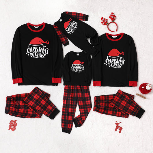 Family of four wearing matching red and black plaid Christmas pajamas with "Christmas CREW" graphic, children in Santa hats. - Image 8