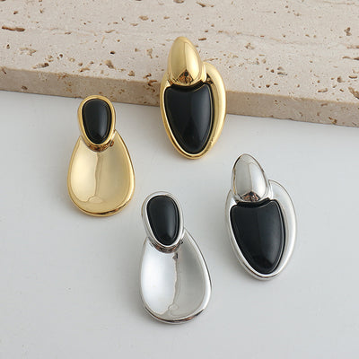 Pair of gold-toned irregular earrings with black onyx-like inserts, featuring a modern, abstract design. - Image 23