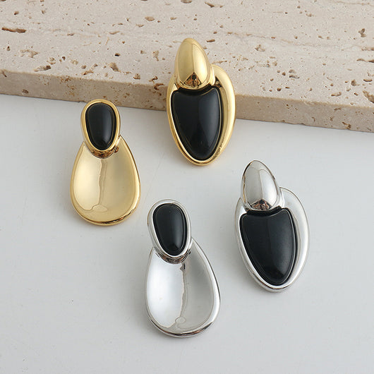 Pair of gold-toned irregular earrings with black onyx-like inserts, featuring a modern, abstract design. - Image 23