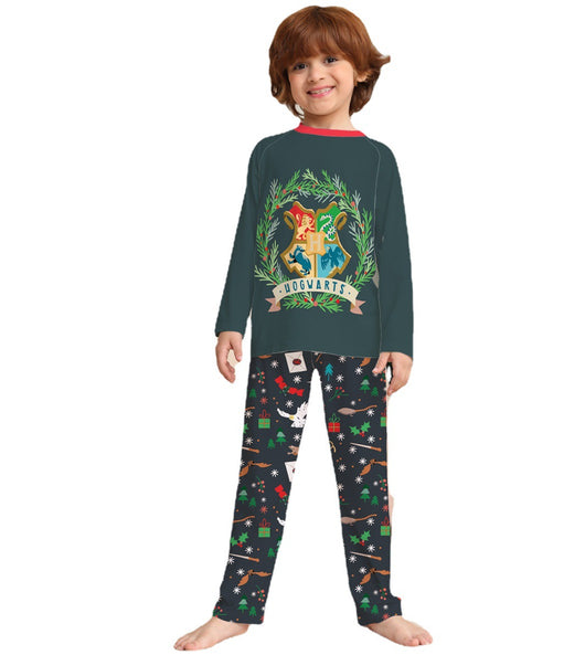 Family of four wearing matching dark green Hogwarts pajamas with a festive Harry Potter pattern, posing by a Christmas tree. - Image 4