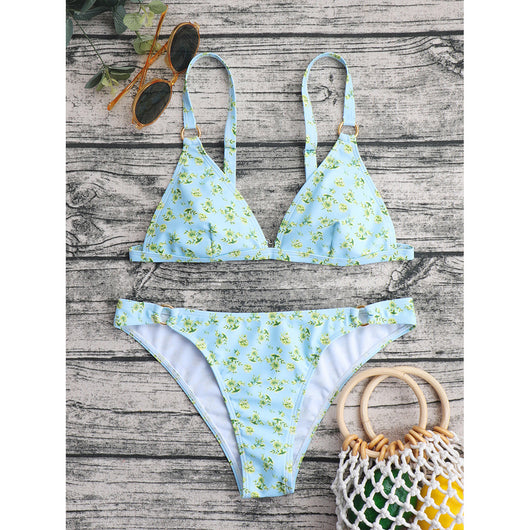 Woman smiling in a white bikini with blue floral print, triangle top, and briefs bottoms, on a sunny beach. - Image 83