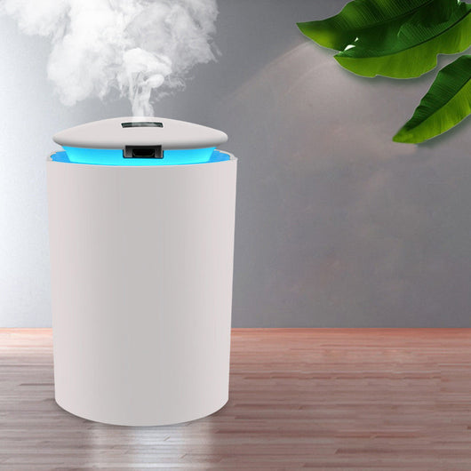 White cylindrical USB mini humidifier with blue LED light, emitting a fine mist, suitable for home or car.