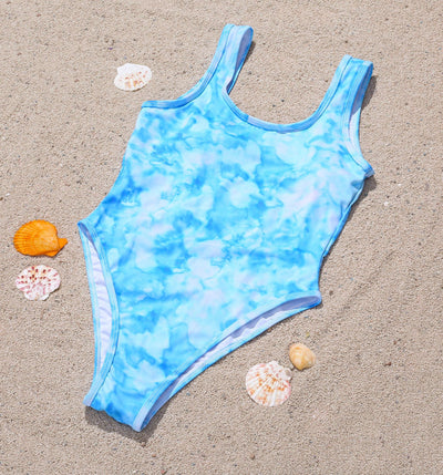 Woman in a blue and white tie-dye one-piece swimsuit with a halter neckline, accessorized with gold necklaces. - Image 5