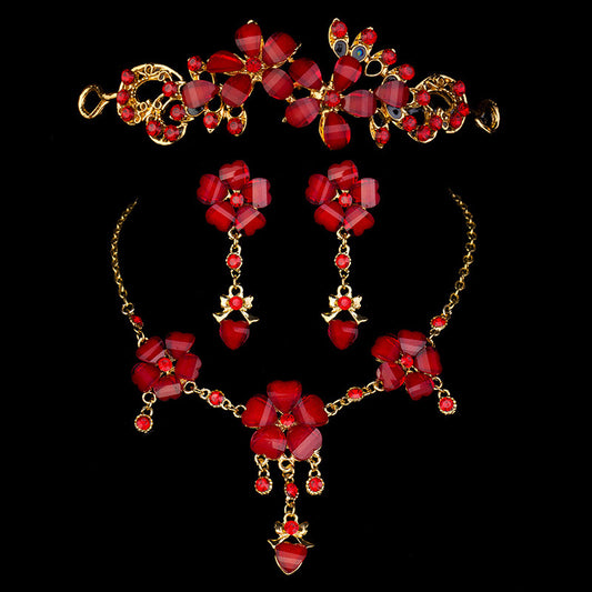 Red floral and heart gemstone bridal jewelry set with gold-toned tiara, necklace, and dangle earrings.