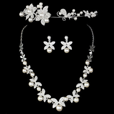 Elegant bridal jewelry set featuring a pearl and rhinestone floral necklace with matching drop earrings on a model.