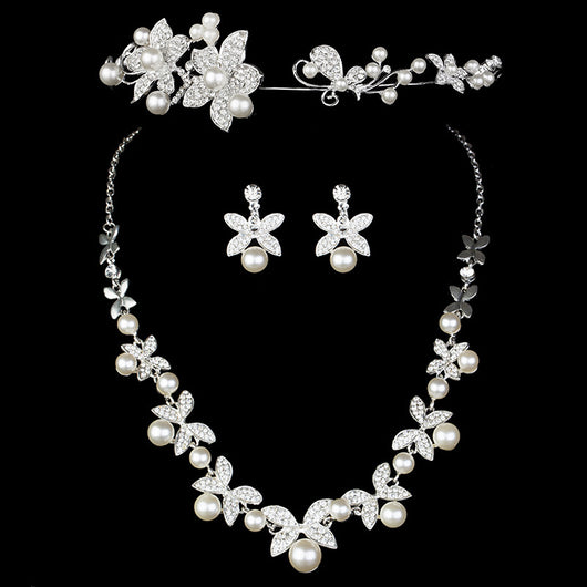 Elegant bridal jewelry set featuring a pearl and rhinestone floral necklace with matching drop earrings on a model.