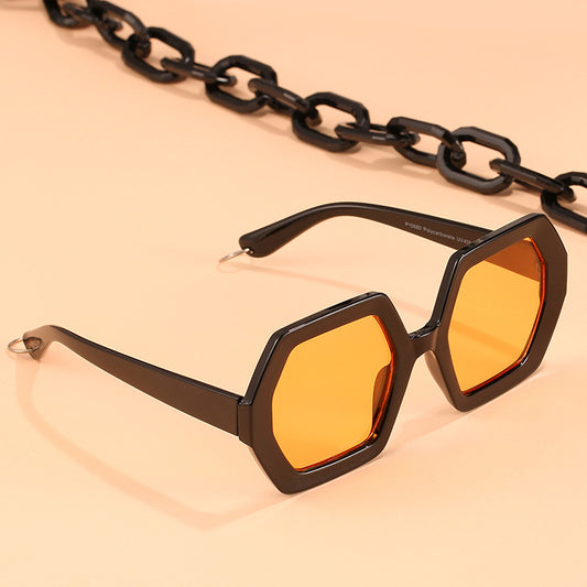 Octagonal sunglasses with brown gradient lenses and a tortoiseshell chain strap on a white background.
