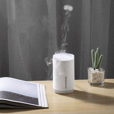 Porcelain white cylindrical humidifier emitting jellyfish-shaped mist, sitting on a round base against a split teal and dark green background. - Image 8