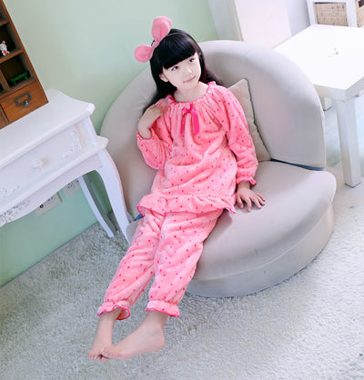 Young woman wearing a pink coral fleece thermal pajama set with white and red polka dots and ruffled hems. - Image 9