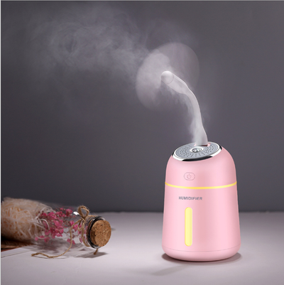 Light blue mini ultrasonic humidifier with a silver top, power button, and clear water level indicator. - Image 2