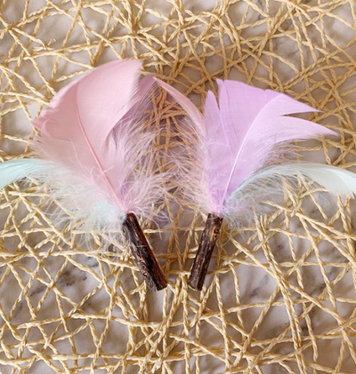 Green catnip ball toy with pink, purple, and white feathers attached, designed for cats to play and nibble. - Image 5