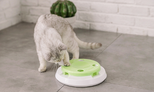 Round electric cat toy with a white base and a lime green top, featuring a rotating white feather. - Image 3