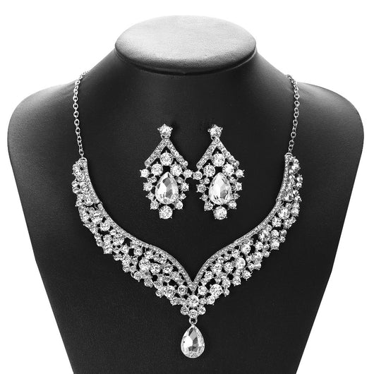 Sparkling silver-tone necklace and matching earrings set with clear round and teardrop rhinestones on a black display. - Image 4