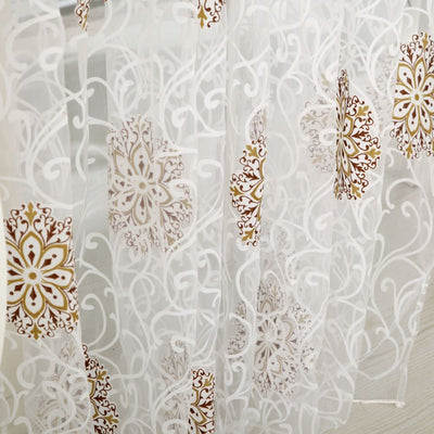 Sheer white European-style floral curtain with brown and gold patterns, hung on a gold rod in a bedroom. - Image 2