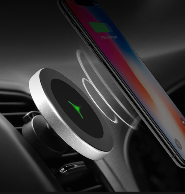 Silver and black car magnetic wireless charger with a blue indicator light, mounted on a car's air vent.
