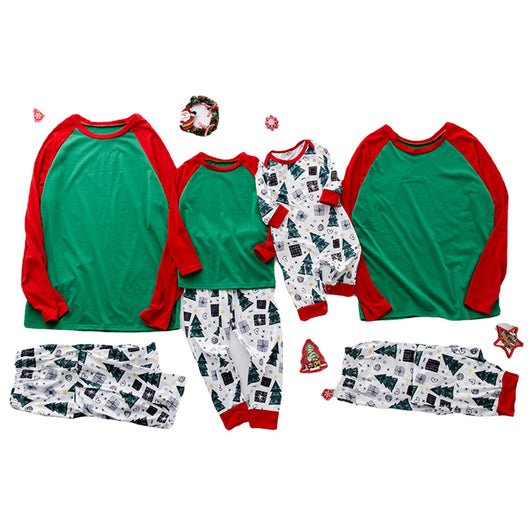 Family of four in matching red and green Christmas pajamas with tree and gift prints, mother holds baby romper. - Image 5