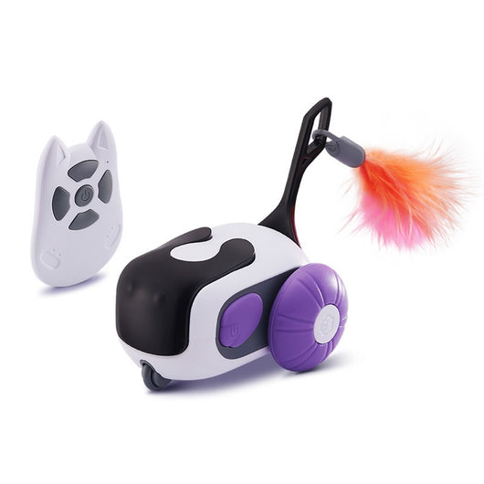 White and black remote control cat toy car with purple wheels and an orange feather, next to a white cat-shaped remote. - Image 5
