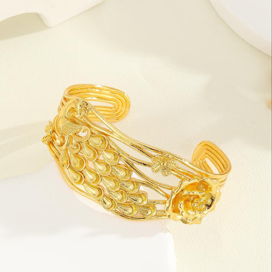 Vintage luxury gold-colored cuff bracelet with intricate carved peacock and flower patterns, featuring multiple bands. - Image 2