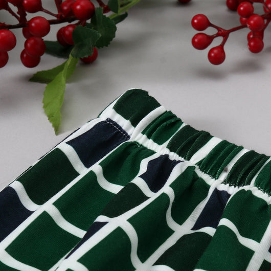 Matching family Christmas pajamas with white and black raglan tops featuring a green Christmas tree graphic and plaid pants. - Image 10