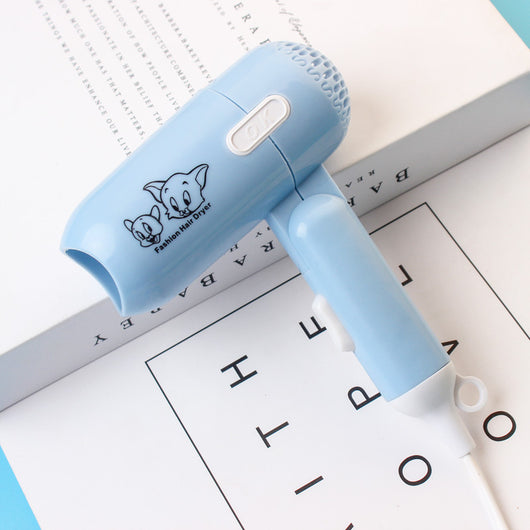 Light blue foldable hair dryer with a cartoon pig design, white power switch, and hanging loop. - Image 6
